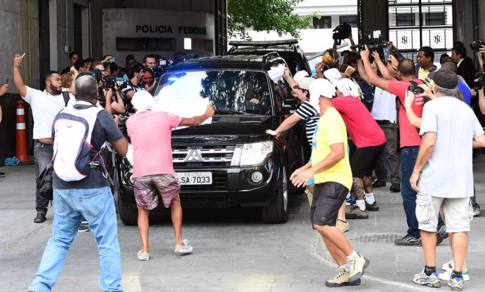 Manifestantes com guardanapos na cabeça acompanham saída de Cabral da PF - TASSO MARCELO / AFP 