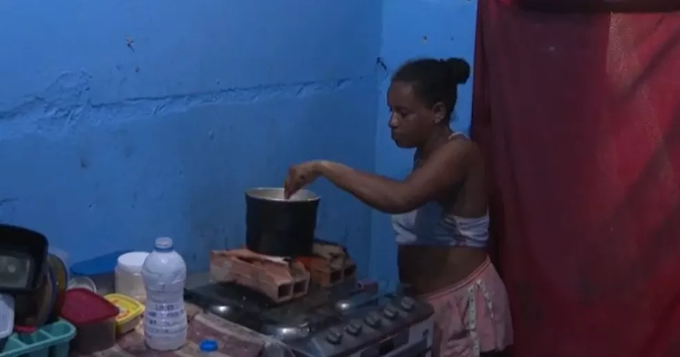 Mulher compra álcool combustível para cozinhar após aumento no preço do gás na Bahia